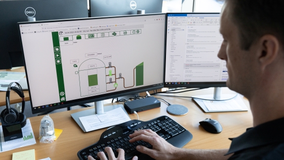 GreenFarm medarbejder sidder ved skærm og tastatur og arbejder