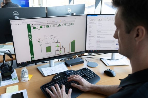 GreenFarm medarbejder sidder ved skærm og tastatur og arbejder